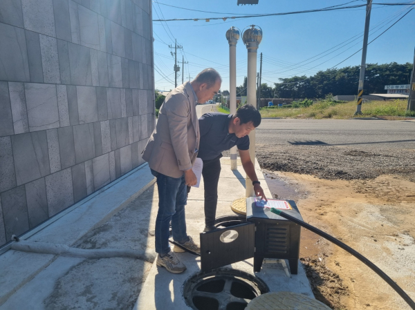 올해 10월 준공된 개인하수처리시설에 서산시 직원이 스티커를 부착하고 관계자에게 설명하는 모습