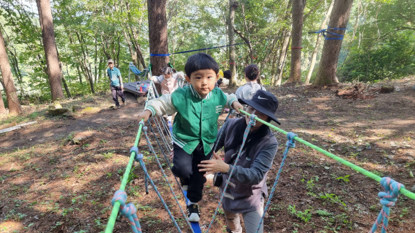 어린이가 지난 14일 김천치유의숲 치유놀이터에서 산림치유지도사의 안내에 따라 밧줄타기를 하며 건너고 있다