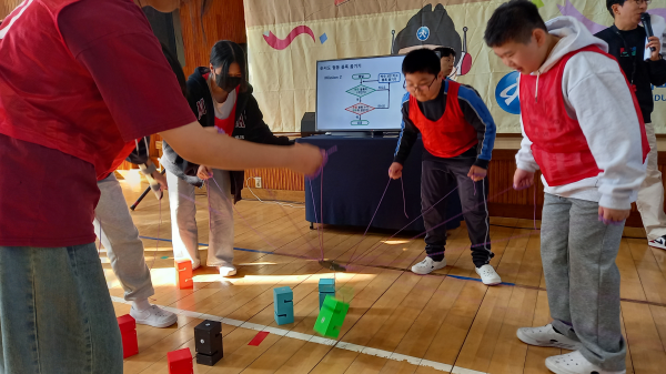 학생들이 순서도를 보고 협동하여 블록을 옮기는 경기 모습