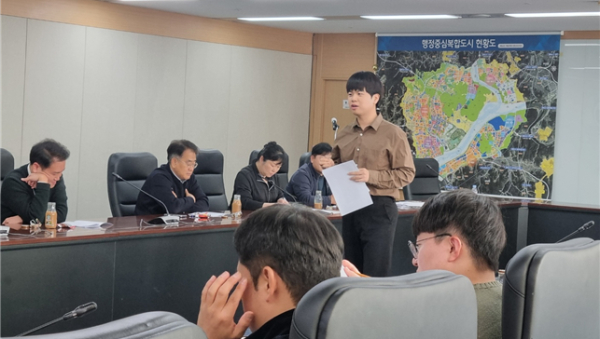 행복청 김명린 주무관(가운데)이 12.2(월) 행복청 종합상황실에서 시설사업국장(윗줄 왼쪽에서 두 번째)과 건설사업 담당자 등을 대상으로 건설사업 매뉴얼에 대해 설명하고 있다