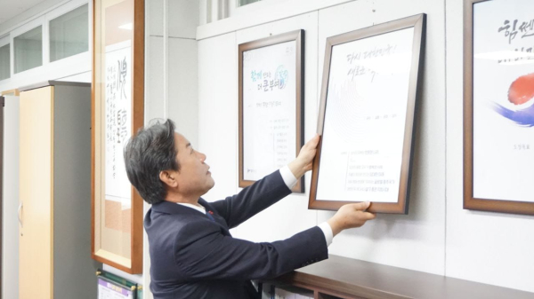 박정현 군수가 군수실에 걸려있는 국정목표 액자를 떼어내고 있다.