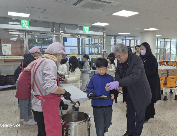천범산 부교육감과 늘봄업무 담당자들이 25일 해밀초등학교 급식실에서 아이들의 급식을 점검하고 있다.