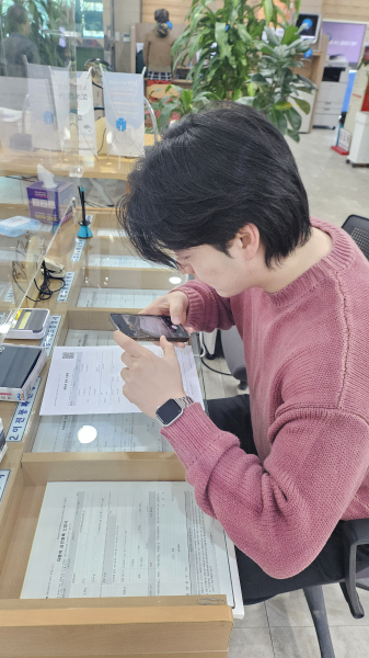 민원인이 지방세 신청서를 작성하기 위해 QR코드를 스캔하고 있다.