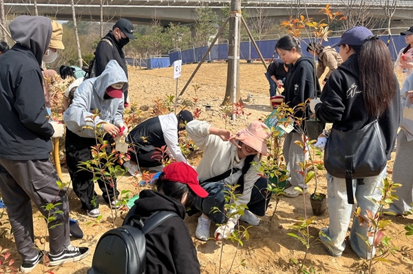 대전 서구 도안동 갑천생태호수공원에서 열린 나무심기 행사에서 목원대 국제교육원 한국어연수과정 수강생들이 나무를 심으며 기념촬영을 하고 있다.
