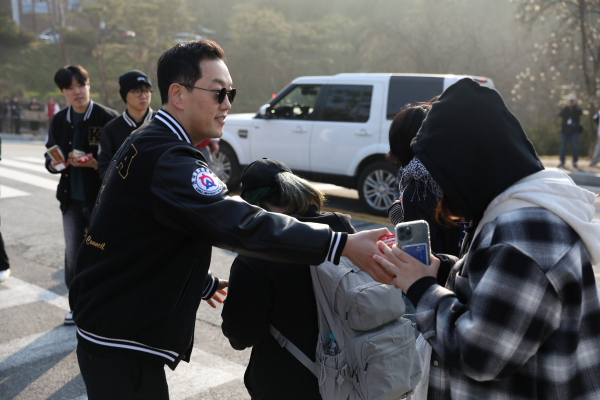한국영상대학교 유주현 총장이 등교케어 행사에서 학생들에게 아침 간식을 건네주고 있다