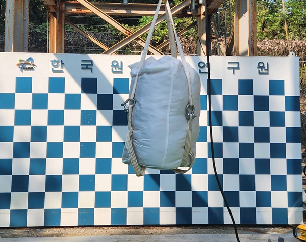 비분산 포장재에 입자성 물질 함유 폐기물 모사 시료를 넣은 후 낙하 시험을 수행하고 있다.