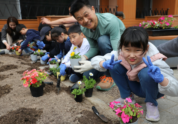 박석희(우측 두 번째) 국립춘천숲체원장이 17일 강원도 춘천시 신북읍 춘천숲체원 누리관 앞에서 오동초등학교 어린이들과 봄꽃을 심으며 포즈를 취하고 있다.