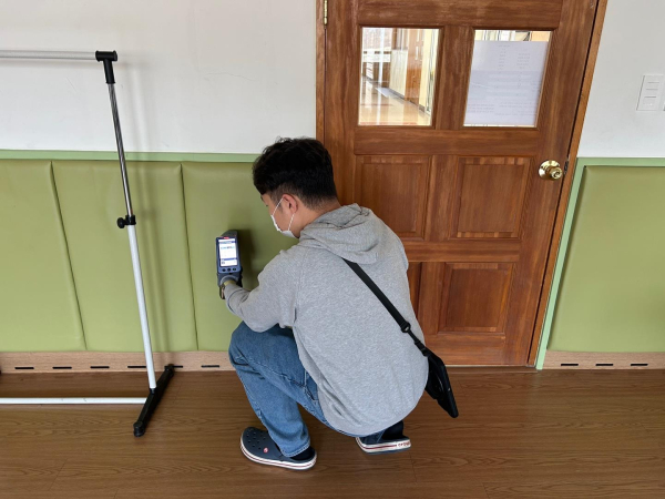 점검기관(fiti시험연구원)의 점검원이 으뜸초등학교에서 특별교실의 건축마감재의 중금속 간이검사를 실시하고 있다.