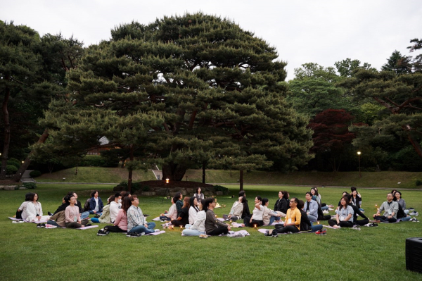 청와대 녹지원에서 동반자와 함께 등을 맞대고 싱잉볼 프로그램을 체험하고 있는 참여자들.