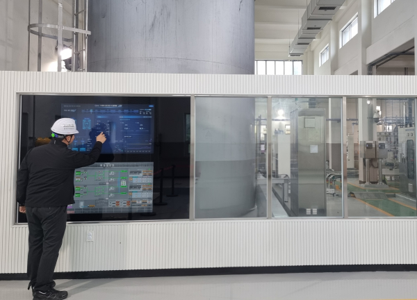 공사 관계자가 경기도 화성에 있는 AI 정수장에서 약품주입동에 구현된 ‘스마트 미러’(터치형 화면)를 보며 정수처리에 필요한 약품주입 자율공정 현황 등을 살펴보고 있다.