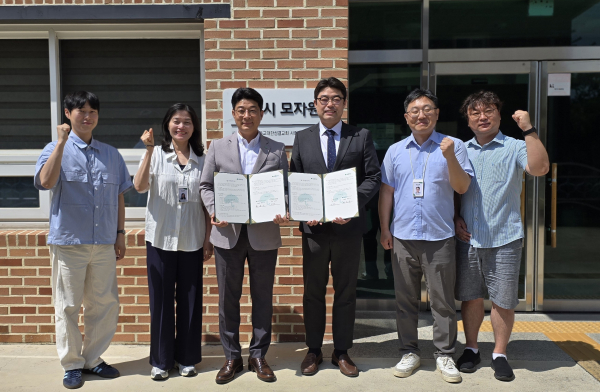 초록우산 최승인 충청권역본부장과 임은국 루시모자원장이 직원들과 함께 업무협약서를 들고 기념촬영을 하고 있다