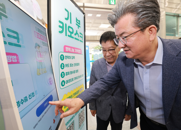 정용래 유성구청장이 유성구청 로비에 설치된 기부 키오스크를 통해 기부를 하고 있다.