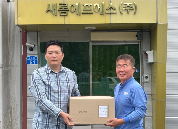 노영래 새롬에프에스 전무(우)가 권능 구산원 원장에게 물품을 전달하고 있다.