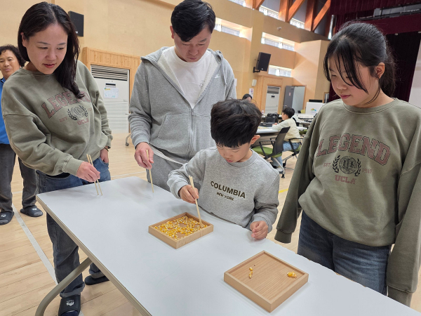 지난 16일 춘천숲체원 어울림관에서 '톡!톡!톡! 가족 소통캠프' 참가 가족이 공감시간 보드게임 미션 중 젓가락 콩 옮기기를 수행하고 있다.