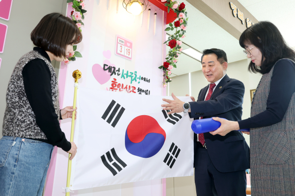 국제결혼 부부 대상 태극기 증정 사업을 앞두고 서철모 구청장이 직원들과 함께 태극기 상태를 점검하며 사업 추진에 만전을 기할 것을 당부하고 있다