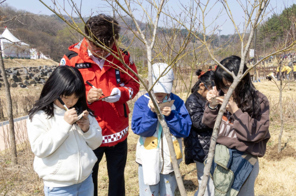 최충규 대덕구청장이 ‘제81회 식목일 기념 나무심기 행사’에서 어린이들과 함께 나무를 심은 후 이름표를 작성하고 있다.