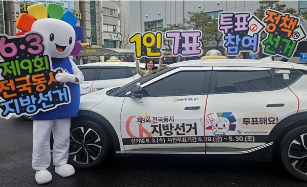 6일 대전광역시선거관리위원회 청사 앞에서 직원들이 꿈돌이 선거택시와 함께 제9회 전국동시지방선거를 앞두고 홍보 피켓 퍼포먼스를 진행