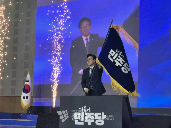 김민석 신임 당대표가 더불어민주당 당기를 휘두르고 있다.